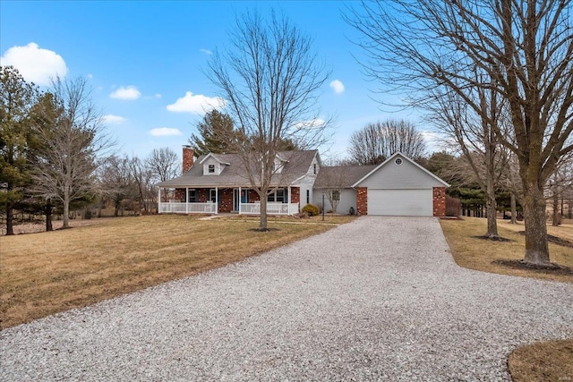 view of front of property with covered porch, a front yard, and a garage