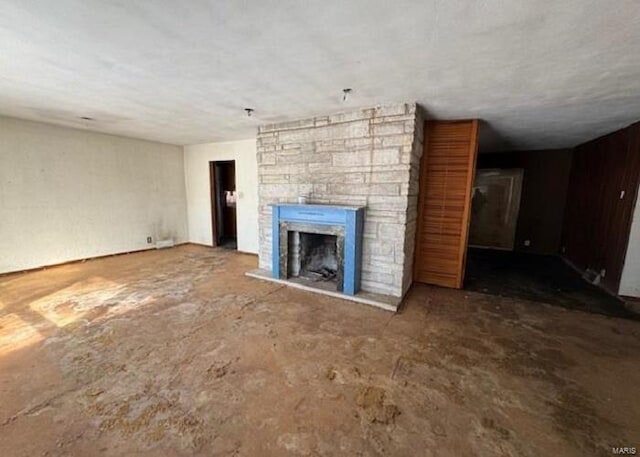 unfurnished living room with a fireplace and concrete flooring