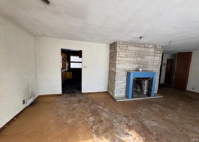 unfurnished living room with a fireplace and concrete floors