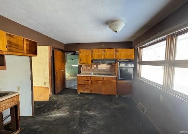 kitchen with wall oven, ventilation hood, and backsplash