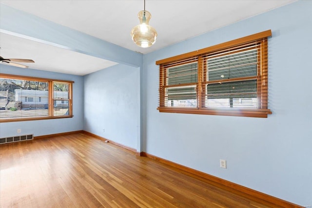 empty room with ceiling fan and light wood-type flooring