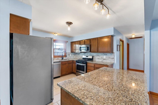 kitchen with sink, light stone counters, light tile patterned floors, stainless steel appliances, and backsplash