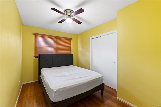 bedroom featuring a closet, dark hardwood / wood-style floors, and ceiling fan