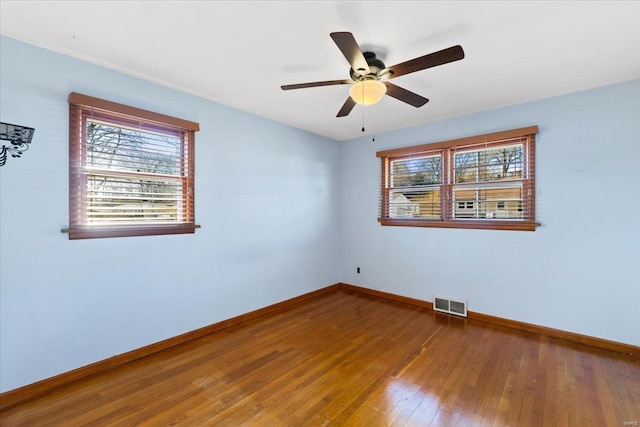 unfurnished room featuring ceiling fan, a healthy amount of sunlight, and hardwood / wood-style floors