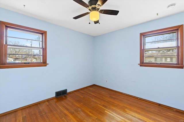 unfurnished room featuring ceiling fan, plenty of natural light, and hardwood / wood-style floors