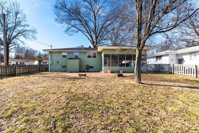 back of property featuring a sunroom and a lawn