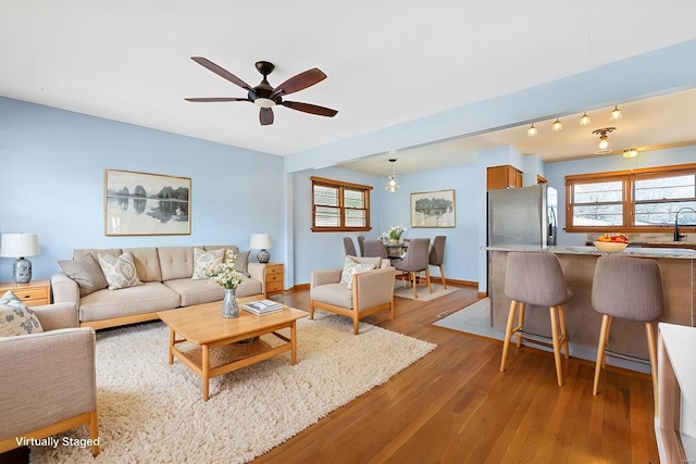 living room with sink, ceiling fan, and light hardwood / wood-style flooring