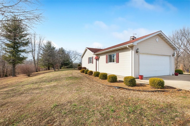 view of side of home featuring a garage and a yard