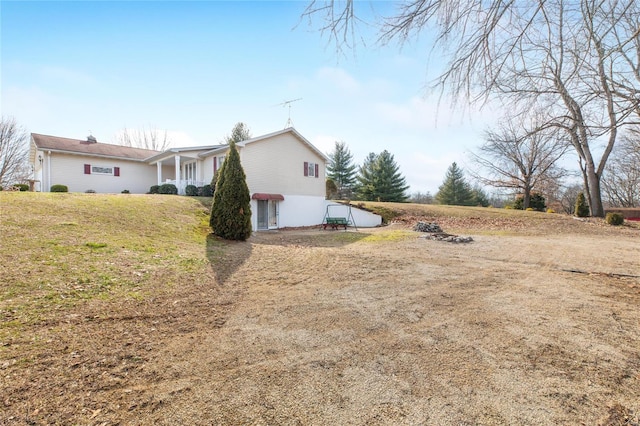 view of side of home with a yard