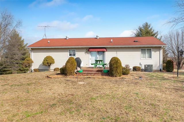 rear view of property with a yard and central air condition unit