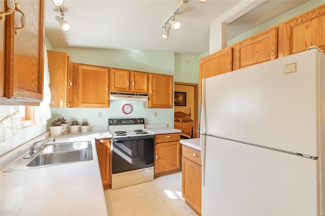 kitchen featuring white appliances, rail lighting, and sink