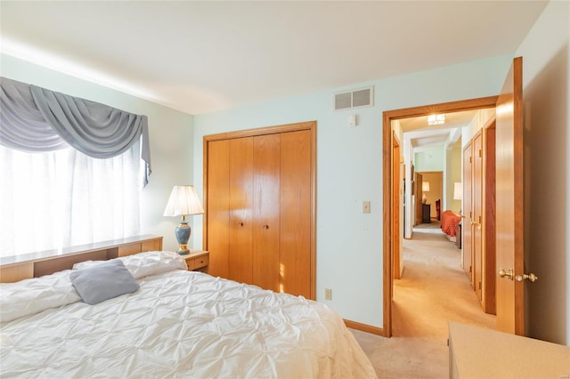 bedroom with light colored carpet and a closet