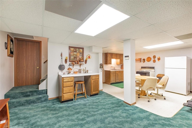 office space featuring a drop ceiling, dark carpet, and indoor wet bar