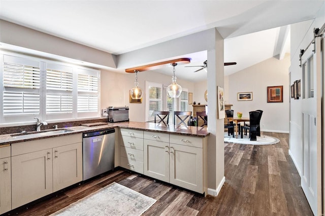 kitchen featuring sink, stainless steel dishwasher, dark hardwood / wood-style floors, pendant lighting, and dark stone counters