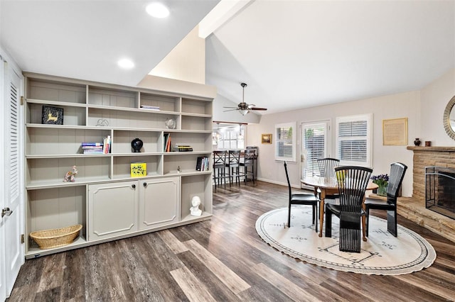 dining area with lofted ceiling, a stone fireplace, ceiling fan, and hardwood / wood-style flooring