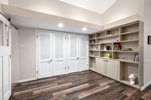 interior space with dark hardwood / wood-style floors and a barn door