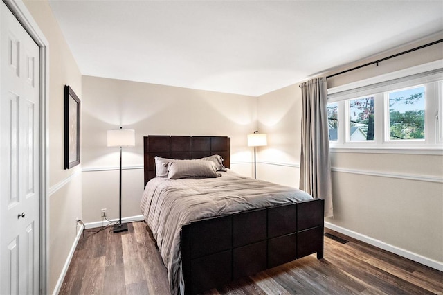 bedroom with dark hardwood / wood-style flooring and a closet