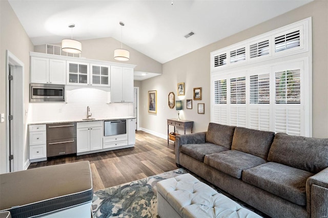 living room featuring sink, vaulted ceiling, and dark hardwood / wood-style floors