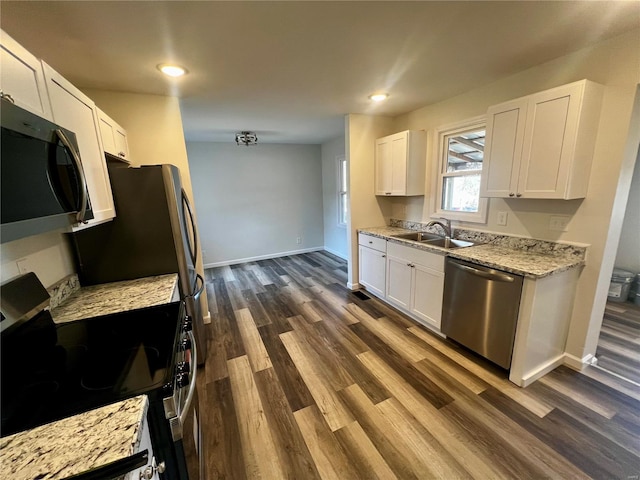 kitchen featuring sink, white cabinetry, appliances with stainless steel finishes, dark hardwood / wood-style flooring, and light stone countertops