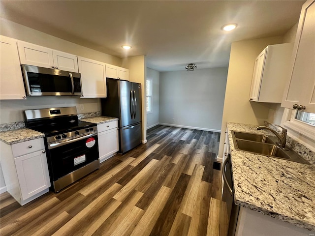 kitchen with appliances with stainless steel finishes, sink, and white cabinets