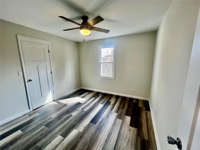 empty room with ceiling fan and dark hardwood / wood-style floors