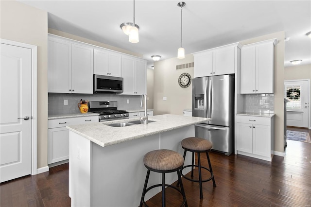 kitchen with white cabinetry, pendant lighting, a kitchen island with sink, and stainless steel appliances