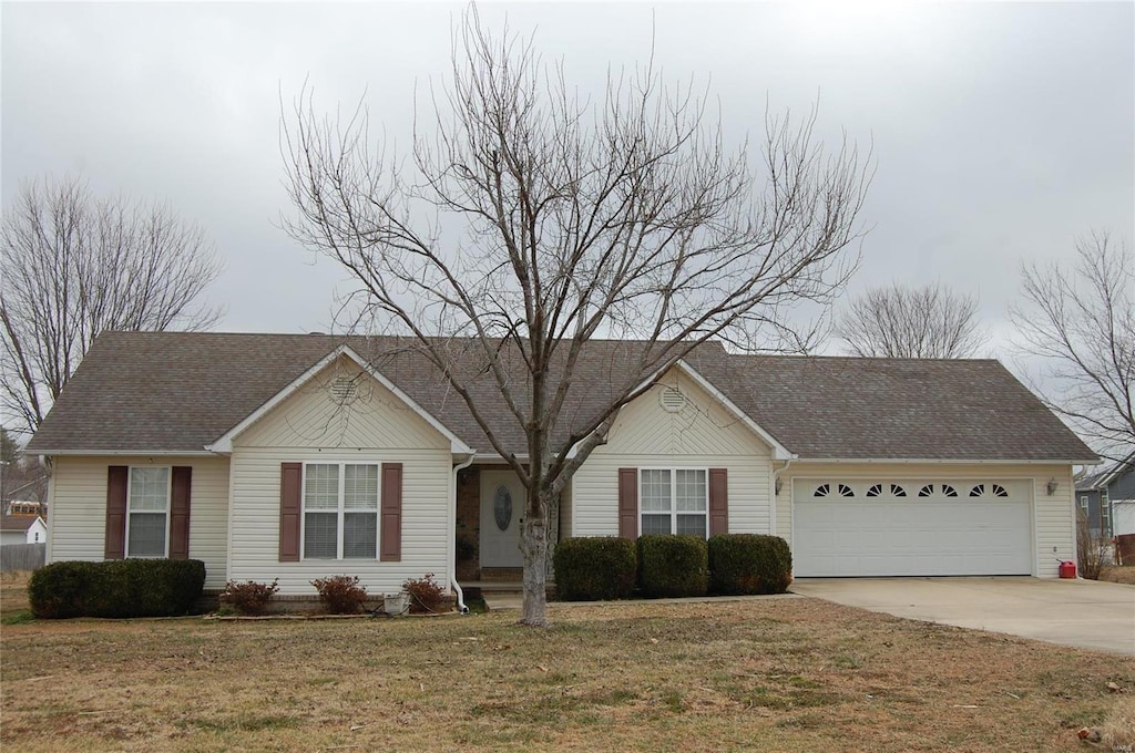 ranch-style home with a garage and a front lawn