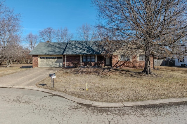 ranch-style house featuring a garage and a front lawn