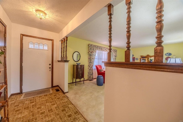 carpeted entrance foyer with a textured ceiling