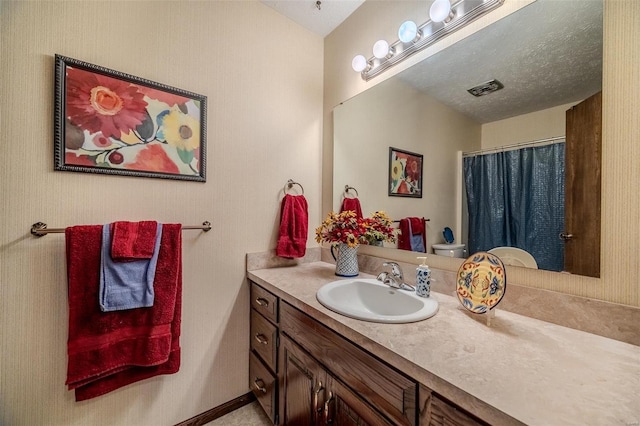 bathroom featuring vanity, toilet, a shower with shower curtain, and a textured ceiling