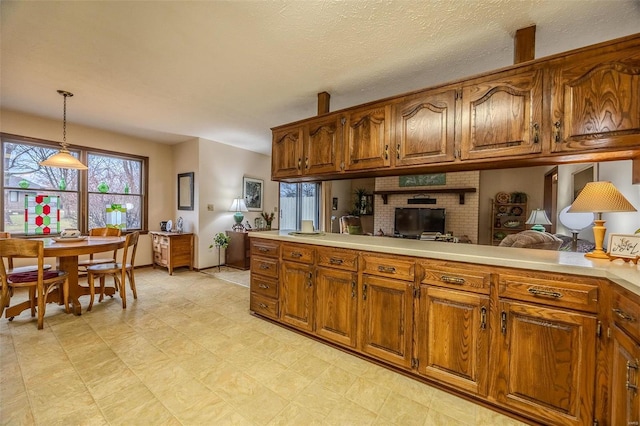 kitchen featuring decorative light fixtures, kitchen peninsula, and a textured ceiling