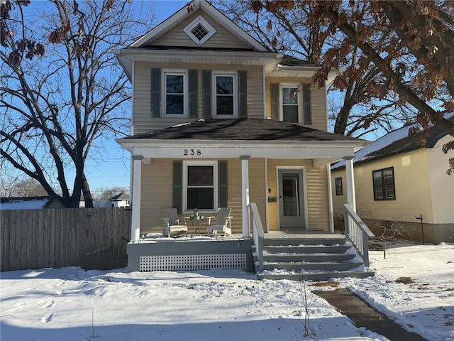 traditional style home featuring covered porch and fence