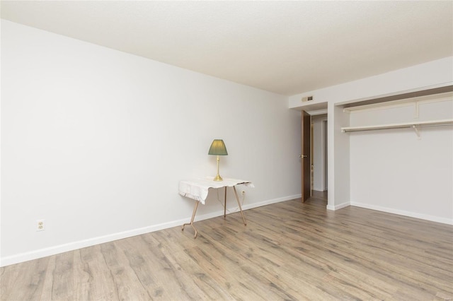 unfurnished bedroom with visible vents, light wood-style floors, baseboards, and a closet