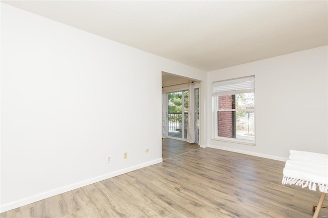 unfurnished room with baseboards and wood finished floors