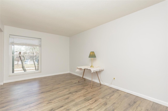 spare room with wood finished floors and baseboards