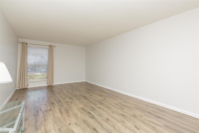 empty room featuring baseboards and wood finished floors