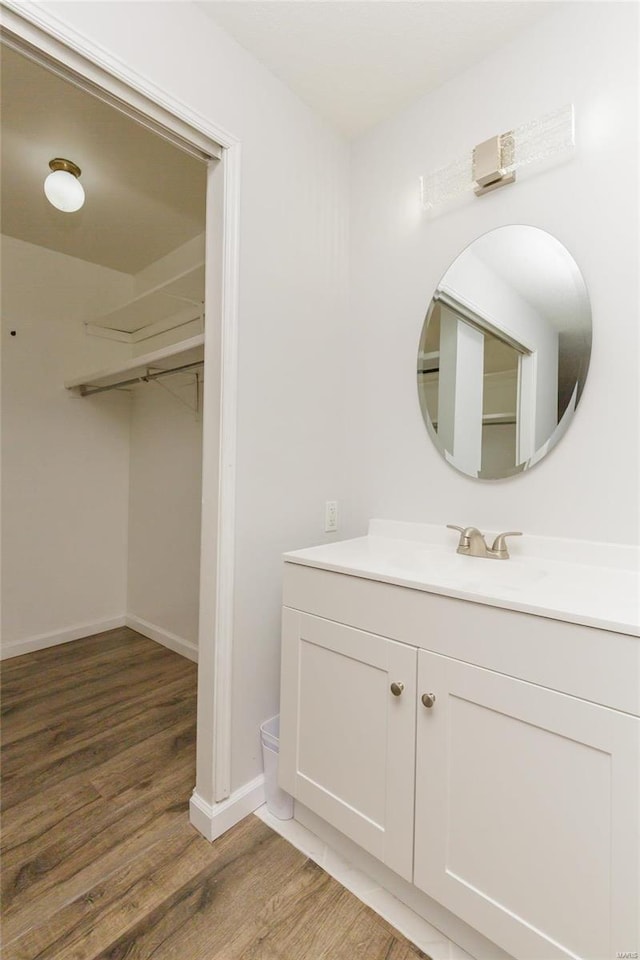 bathroom with baseboards, wood finished floors, and vanity