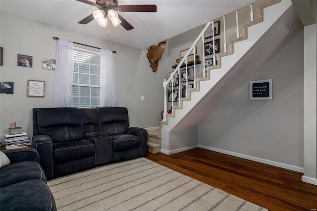 living room with dark wood-type flooring and ceiling fan