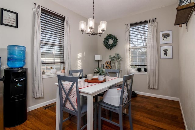 dining area with an inviting chandelier and dark hardwood / wood-style floors