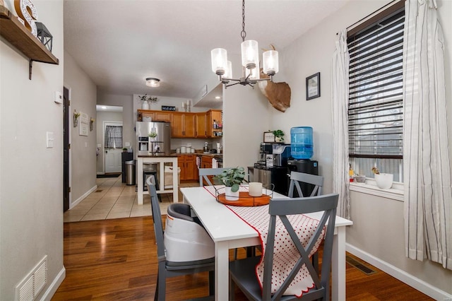 dining area with a notable chandelier and light hardwood / wood-style flooring