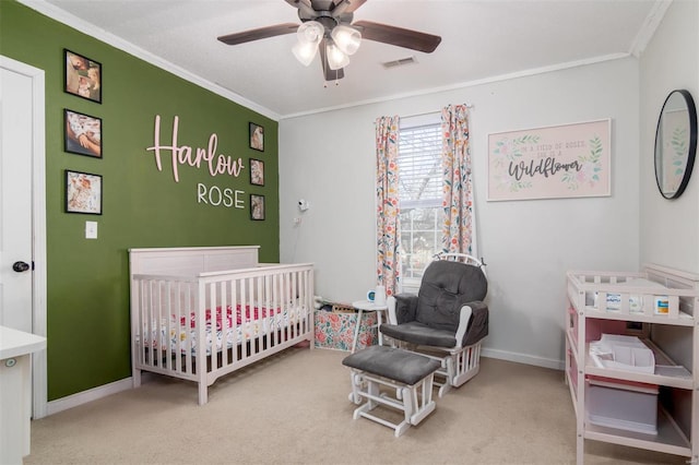 carpeted bedroom featuring a crib, ornamental molding, and ceiling fan