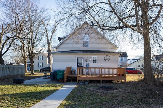 back of house featuring a wooden deck and a yard