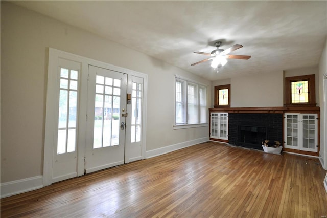 unfurnished living room with hardwood / wood-style flooring, a fireplace, and ceiling fan