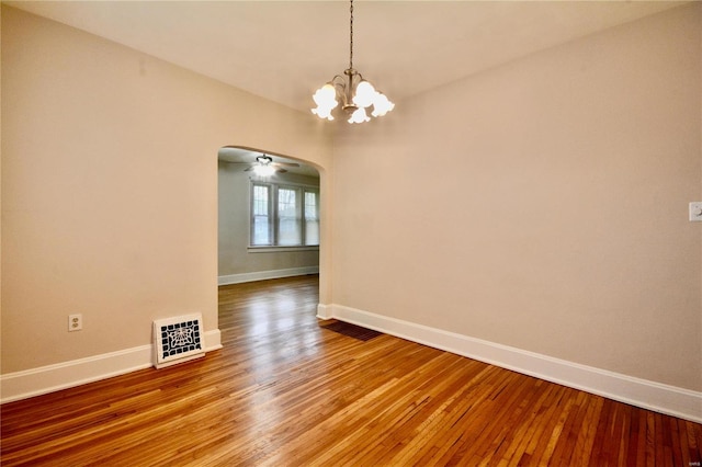 empty room featuring hardwood / wood-style floors and an inviting chandelier