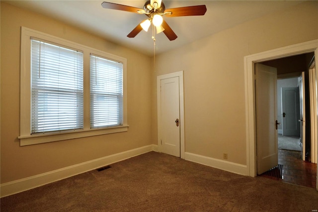 empty room featuring dark colored carpet and ceiling fan