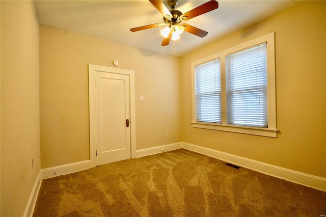 carpeted spare room featuring ceiling fan