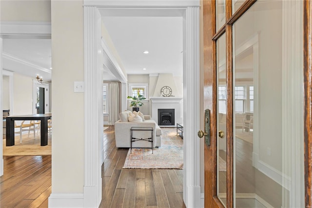 interior space featuring a large fireplace, baseboards, wood finished floors, and recessed lighting