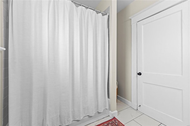 full bath featuring marble finish floor, baseboards, and shower / bath combo with shower curtain