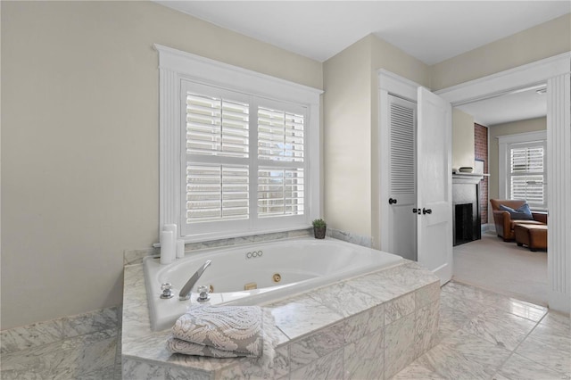 bathroom with a brick fireplace and a tub with jets