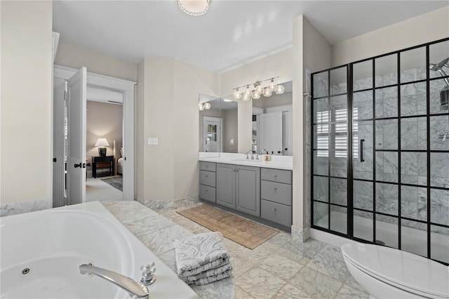 bathroom with baseboards, toilet, a whirlpool tub, marble finish floor, and vanity